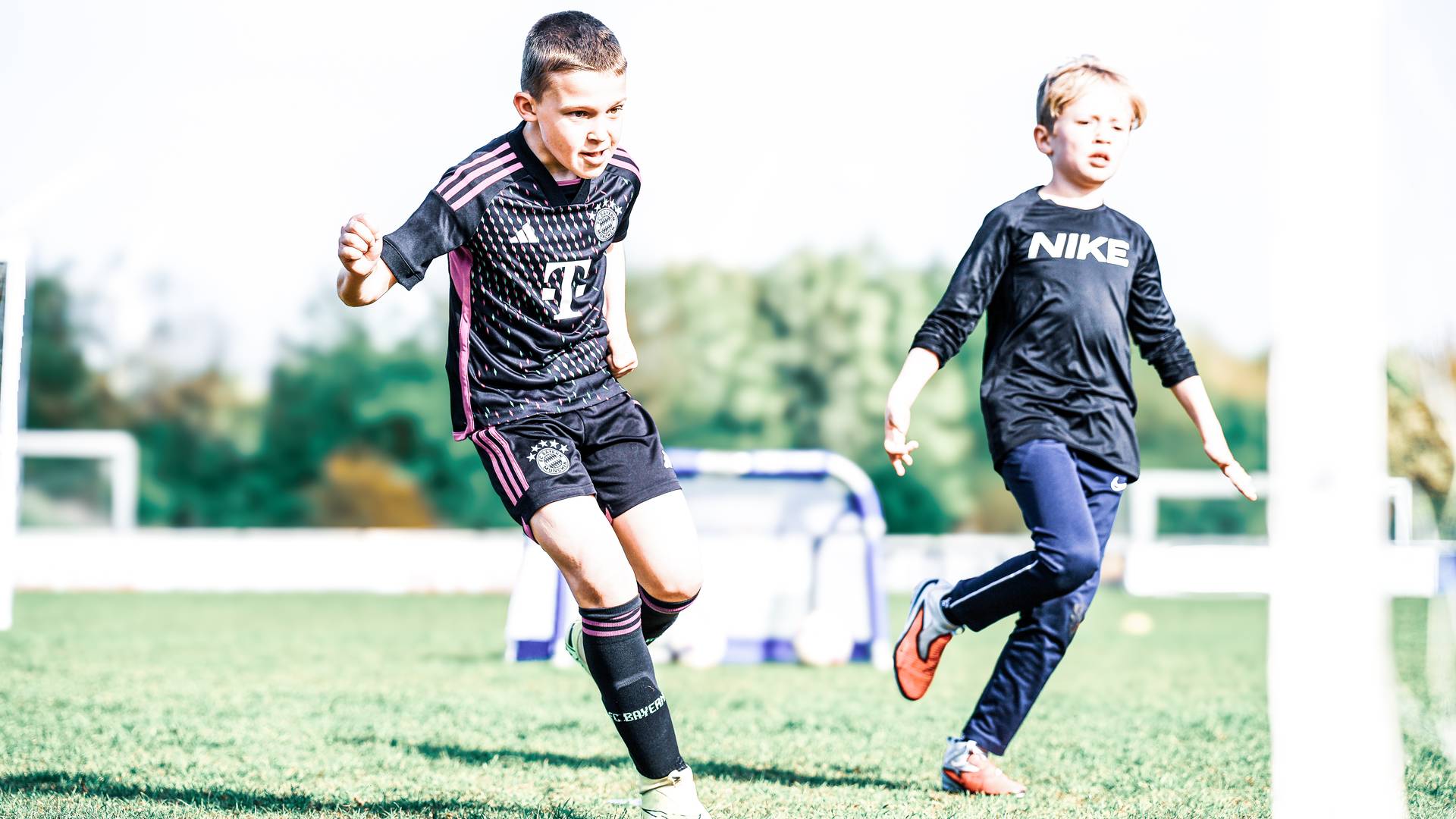 Bring a Friend: zwei Kinder spielen gemeinsam Fußball