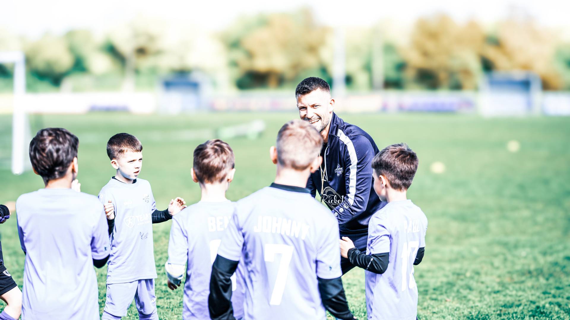 Feriencamps bei Movemania: Trainer im Kreis mit Kindern