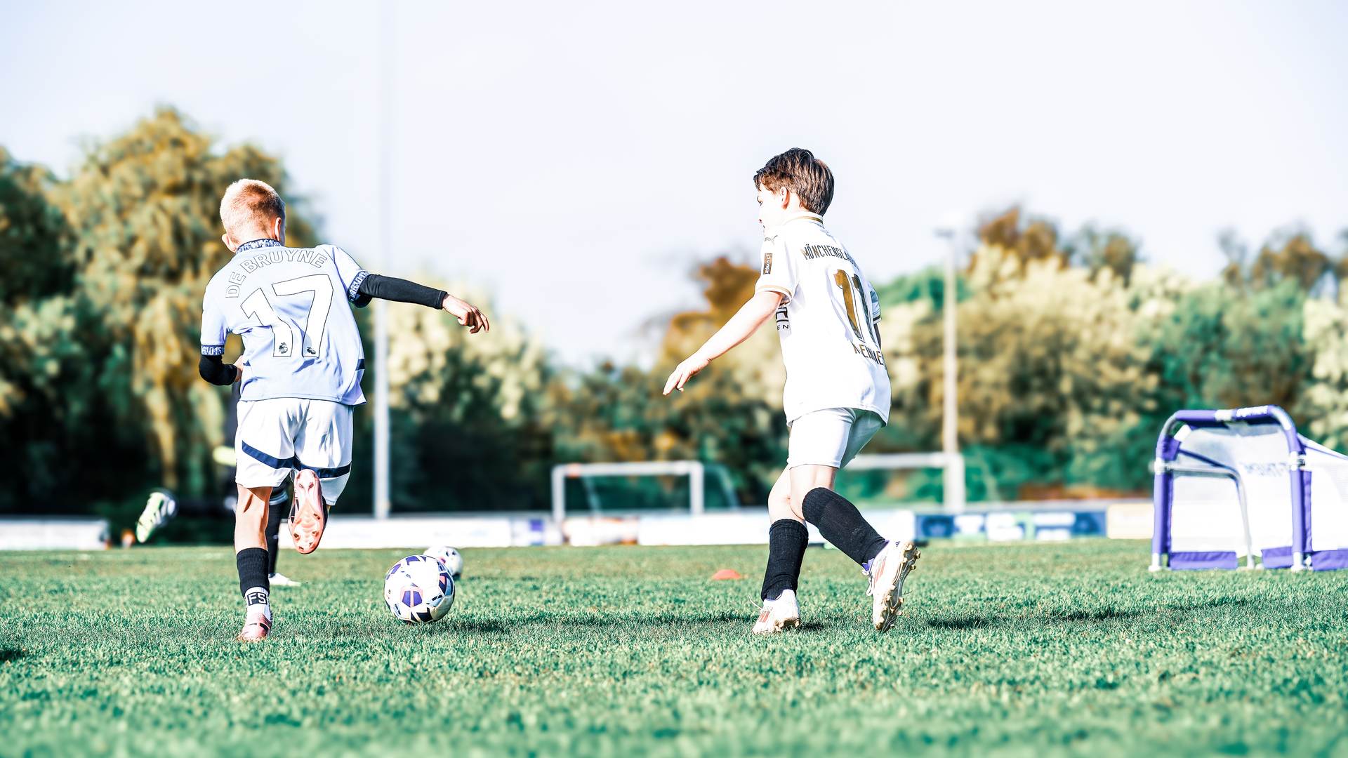 Zwei Kinder spielen sich den Ball zu