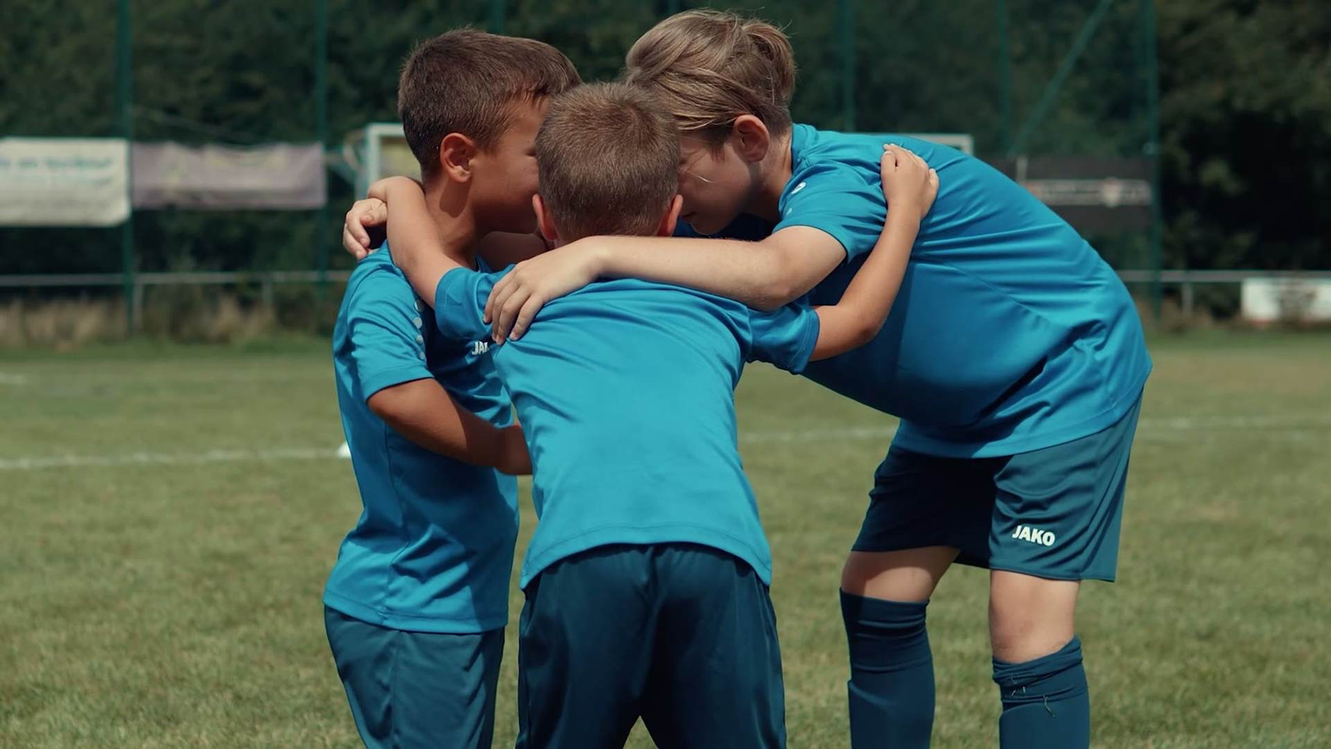 Kinder und Trainer im Teamkreis